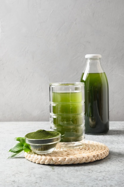 Chlorella healthy beverage in glass on a grey background.