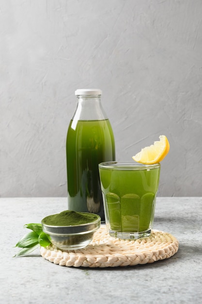 Chlorella healthy beverage in glass on a grey background.