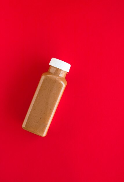 Chocolate banana smoothie bottle on red flatlay