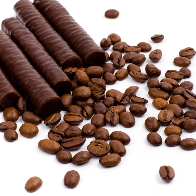 Chocolate bars and coffee beans on white background