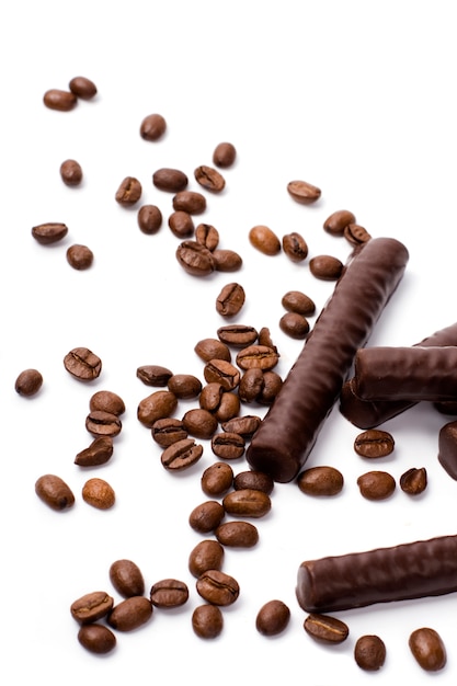 Chocolate bars and coffee beans on white background