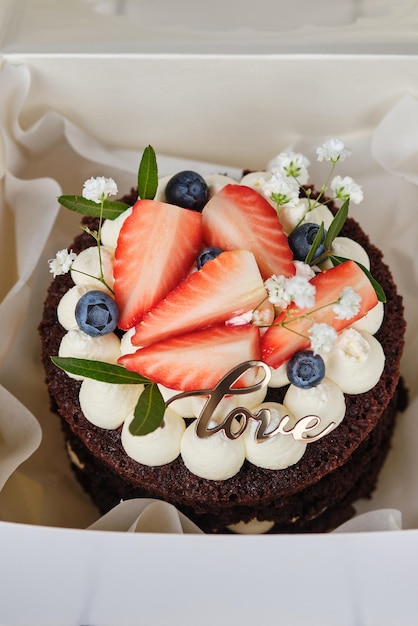 Chocolate bento cake decorated with strawberries blueberries and flowers