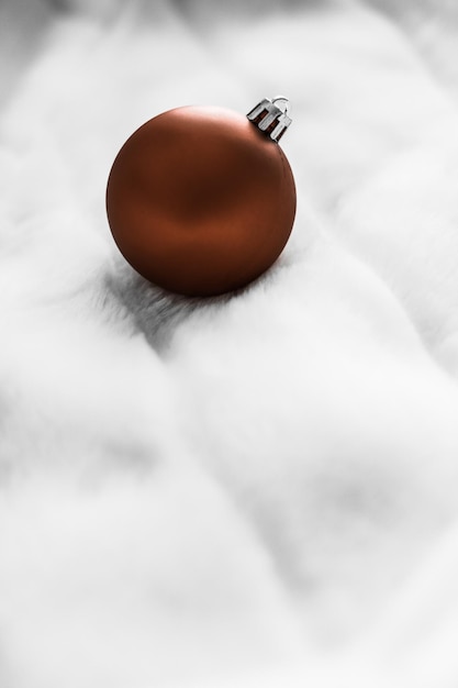 Chocolate brown Christmas baubles on white fluffy fur backdrop luxury winter holiday design background