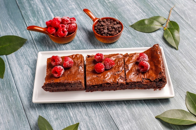 Chocolate brownie cake dessert slices with raspberries and spices,top view