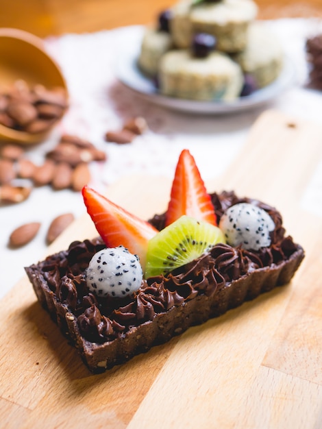 Chocolate brownie cake dessert with fruits on wooden board.