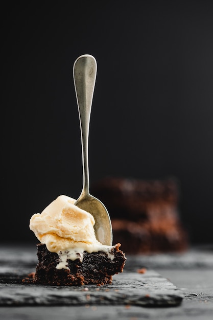 Chocolate brownie and vanilla ice cream on black slate stone