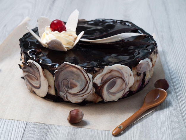 Chocolate cake decorated with a flower of white chocolate and cream