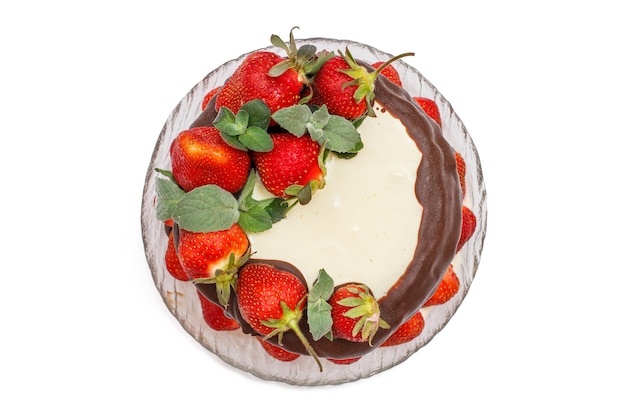 Chocolate cake decorated with fresh strawberries on glass plate in isolated white background