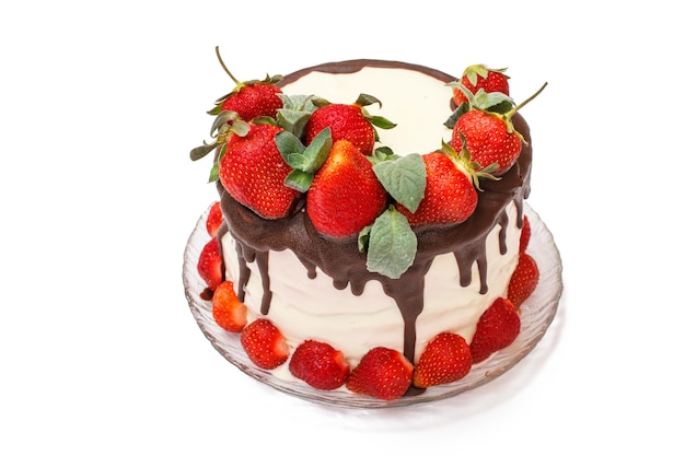 Chocolate cake decorated with fresh strawberries on glass plate in isolated white background