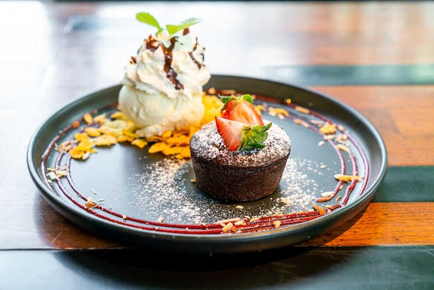 chocolate cake lava with strawberry and vanilla ice-cream on black plate