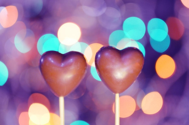 Chocolate cake pops in heart shapes Chocolate covered heart shaped cookies on a stick closeup