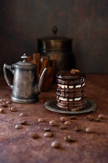 Chocolate cake and vintage coffeepot. Chocolate drops and coffee beans