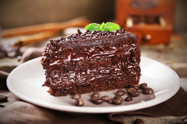 Chocolate cake with chocolate cream and fresh berries on plate, on wooden table