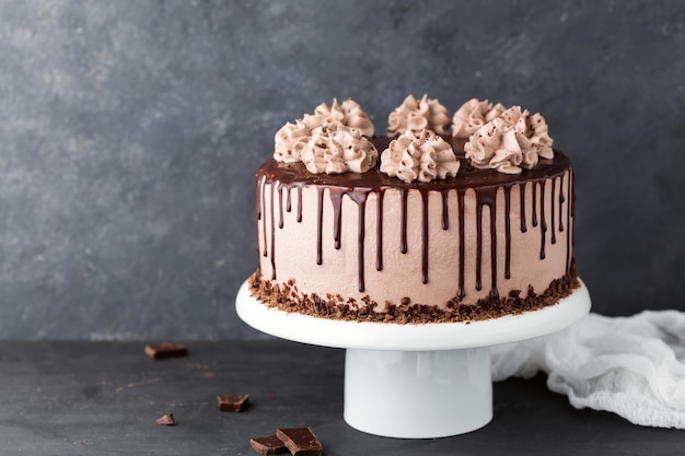 Chocolate cake with coffee cheese cream on a white cake stand