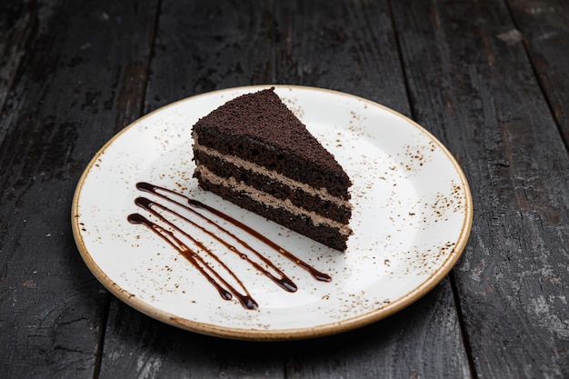 chocolate cake with cream on a wooden background