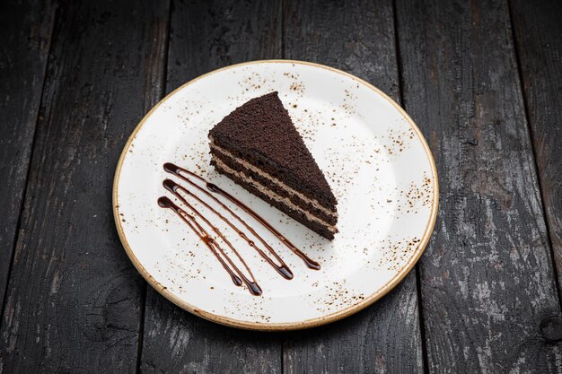 chocolate cake with cream on a wooden background