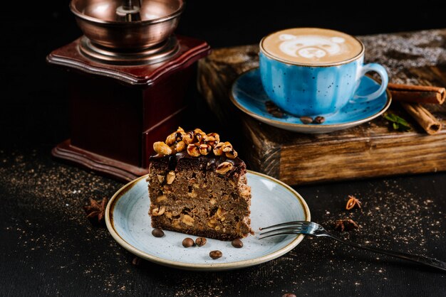 Chocolate cake with nuts in composition with coffee drinks on black