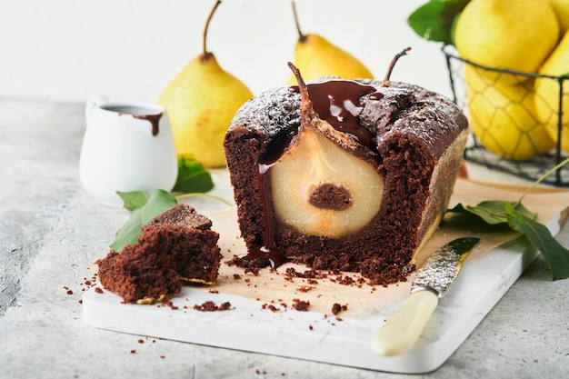 Chocolate cake with pears baked inside Chocolate pear cake or dark chocolate bundt cake with pear on light gray table at home Home cooking and baking recipes concept Selective focus