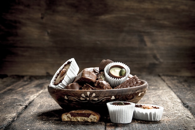 Chocolate candies in a bowl. On a wooden table.