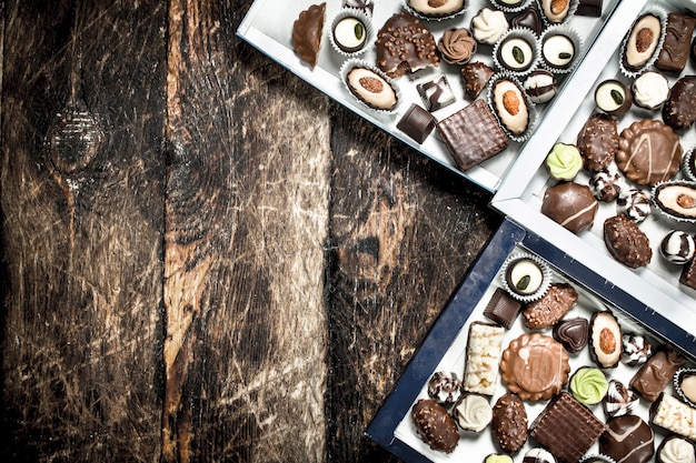 Chocolate candies in a boxes. On a wooden background.