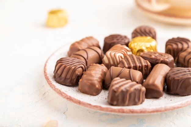 Chocolate candies with cup of coffee side view selective focus