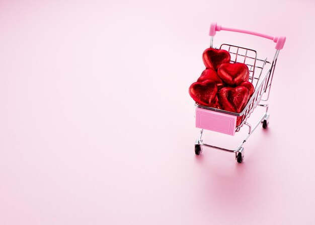 Chocolate Candy Shopping Cart heart on a pink background and space for text