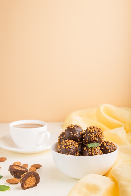 Chocolate caramel ball candies with almonds in a bowl