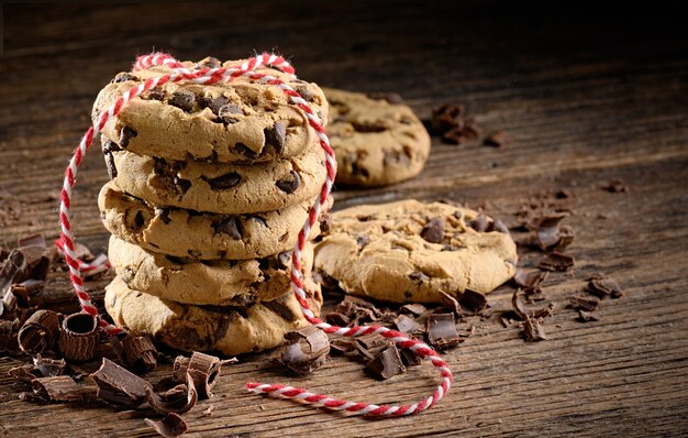 Chocolate chip cookies stack tied with a red rope on wooden rustic table