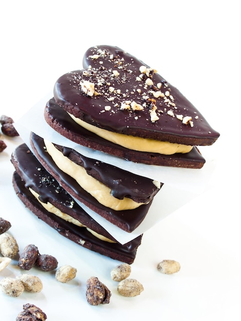 Chocolate cookies with peanut butter filling on white background.