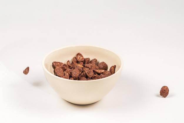 Chocolate corn flakes falling to the white bowl isolated on white Motion