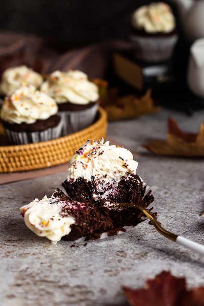 A chocolate cupcake is broken with a fork berry filling is visible