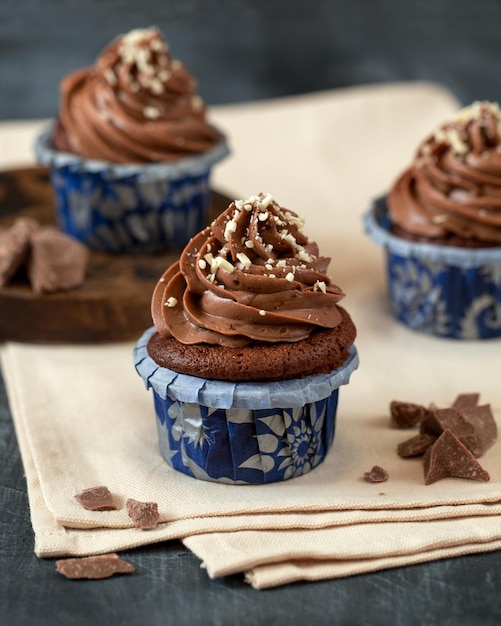 Chocolate cupcake Three muffins on a gray background Pieces of chocolate Sweet dessert