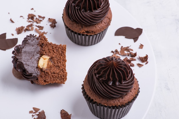 Chocolate cupcake on white plate, top view, close-up