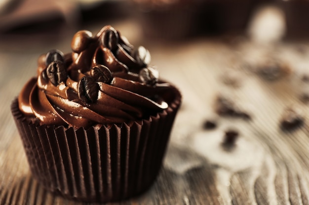 Chocolate cupcakes and coffee beans on wooden table