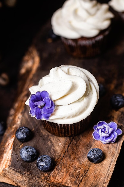 Chocolate cupcakes with blueberries on a dark table