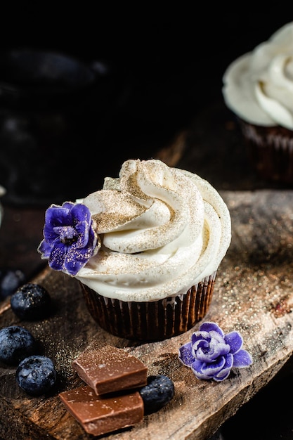 Chocolate cupcakes with blueberries on a dark table