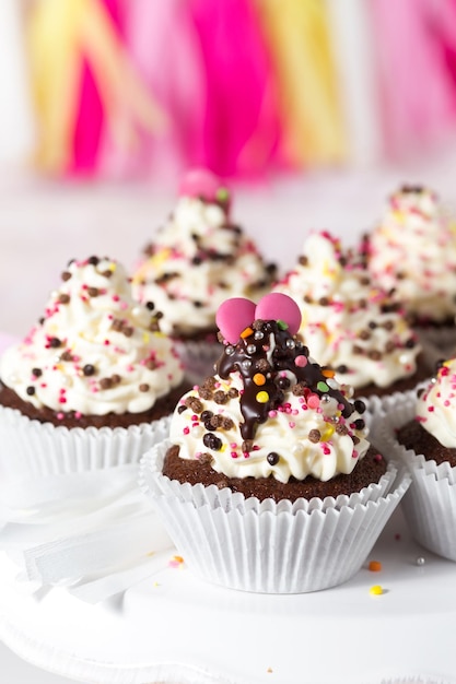 Chocolate cupcakes with white cheese cream ganache and pink decorations