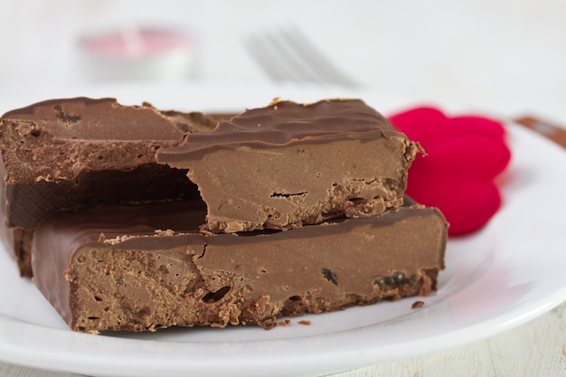 Chocolate dessert on white plate on white wood