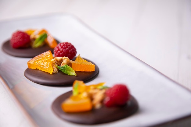 Chocolate dessert with candied orange, raspberry and nuts.