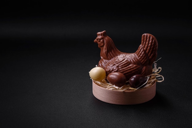 Chocolate Easter hen and eggs in a nest with straw