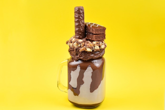 Chocolate extreme milkshake with brownie cake chocolate paste and sweets Crazy freakshake food trend Copy space