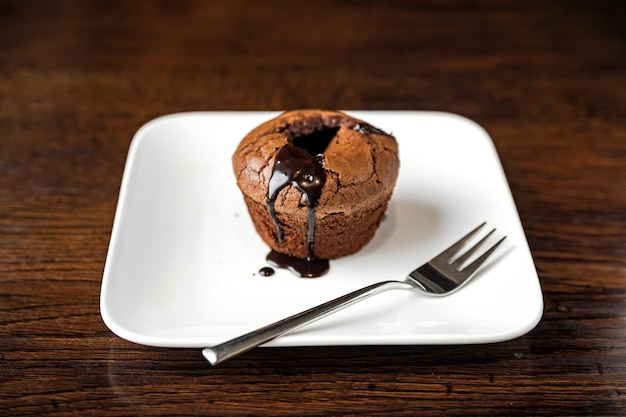 Chocolate fondant dessert on a white plate and a fork