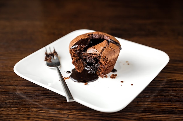 Chocolate fondant dessert on a white plate and a fork