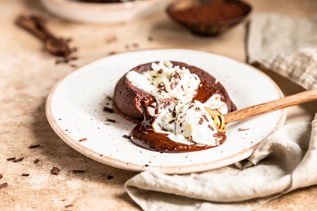 Chocolate fondant or lava cake with whipped cream almond and chocolate pieces Fondant au chocolate