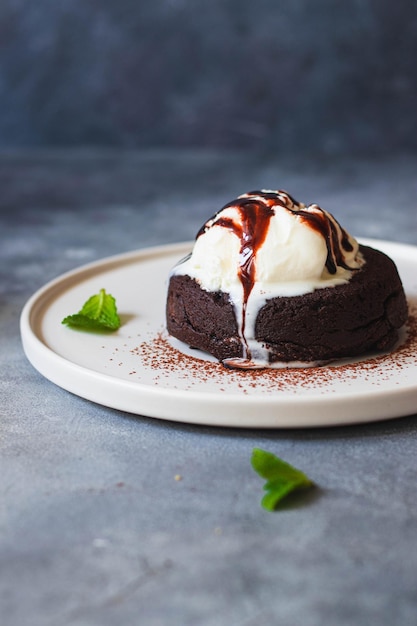 Chocolate fondant with vanilla ice cream ball, chocolate sauce and mint