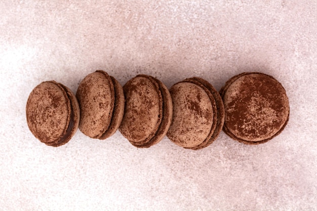 Chocolate french macaroons on a light background. Flat lay top view