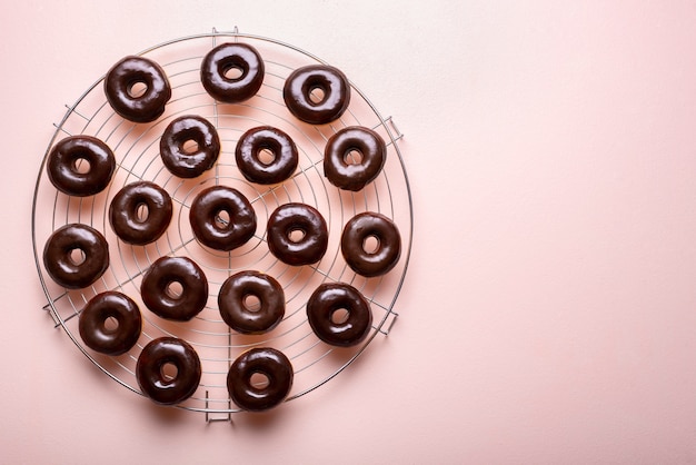 Chocolate glazed doughnuts on a cooling rack. Making choco donuts