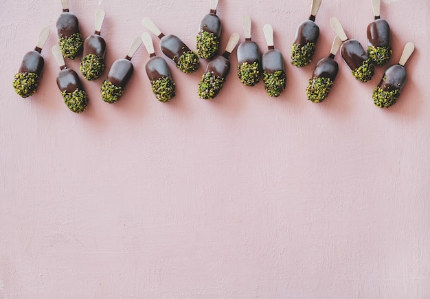 Chocolate glazed ice cream pops with pistachio icing copy space