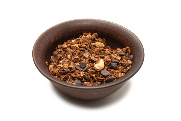 Chocolate granola cereal with nuts in a bowl wall. Isolated on white