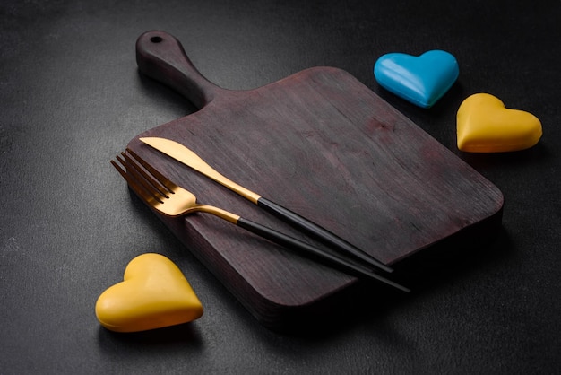 Chocolate hearts in the colors of the Ukrainian flag on a black ceramic plate